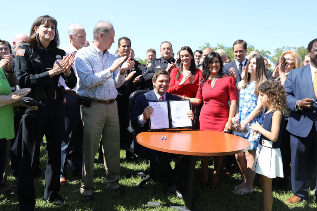 Governor Ron DeSantis holds up the bill he signed today in Sarasota, Florida.