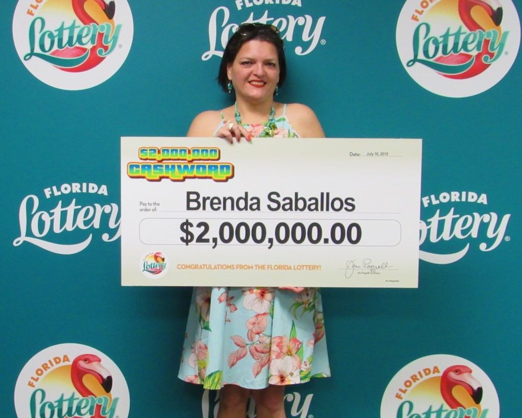 Brenda Saballos poses with her oversized check after claiming a $2 million top prize from the $2,000,000 CASHWORD Scratch-Off game at Florida Lottery Headquarters.