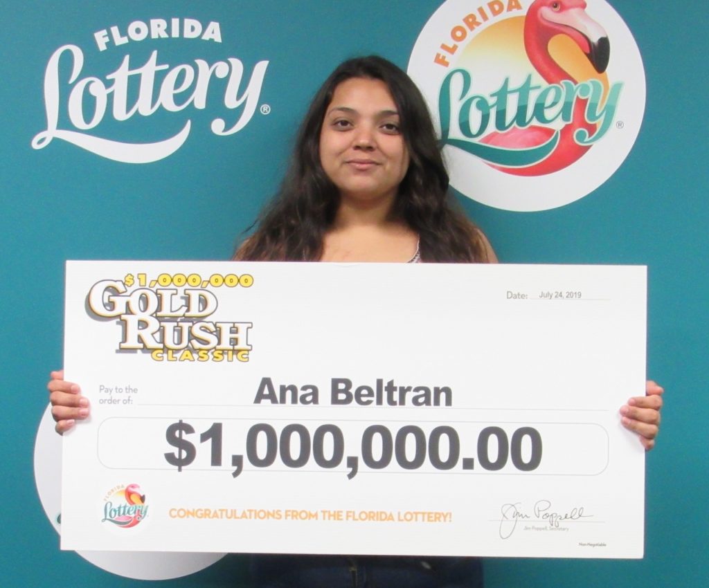 Ana Beltran poses with her oversized check after claiming a $1 million prize from the $5 GOLD RUSH CLASSIC Scratch-Off game at Florida Lottery Headquarters.