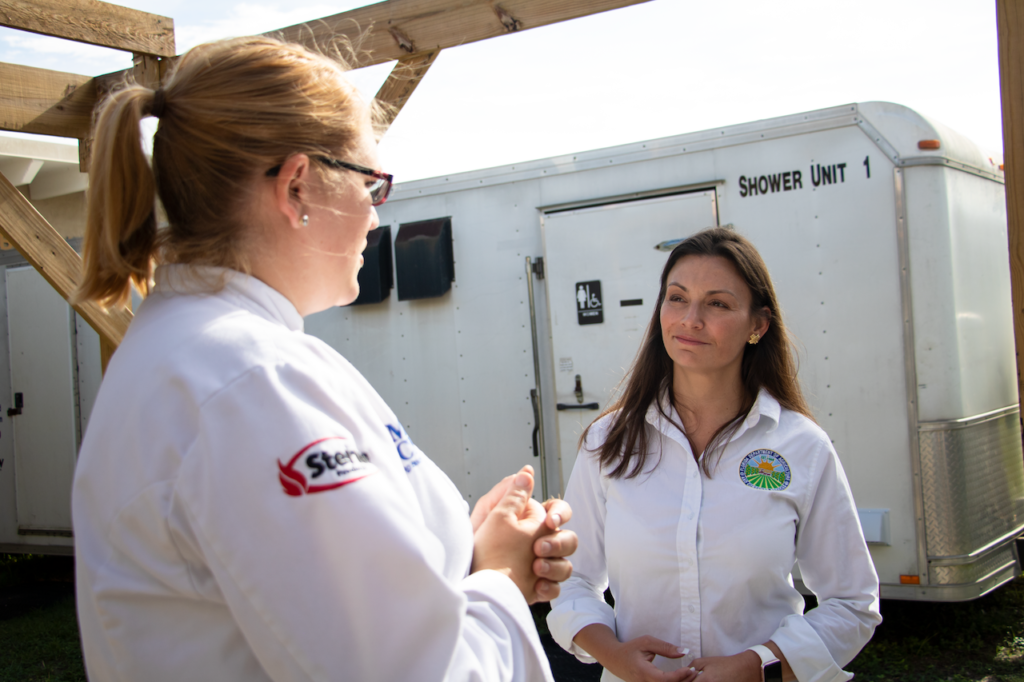 Photograph of Chef Kristin Macan speaking with Commissioner Nikki Fried.