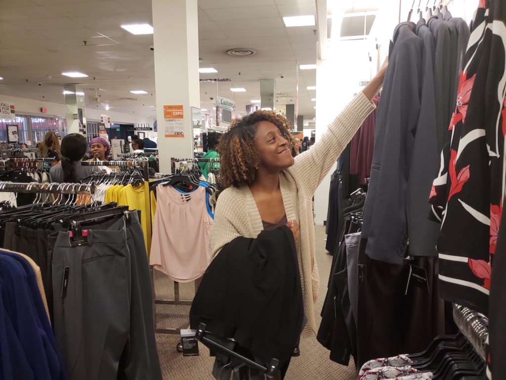 Photograph of female FAMU student selecting items of the racks during the Suit-Up event at JC Penney.