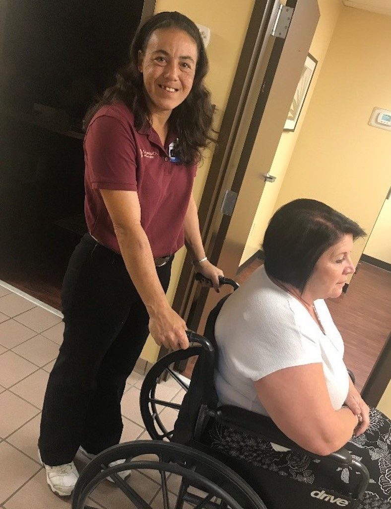 Carrie Hitz transports a patient to a vehicle at AdventHealth Orlando.