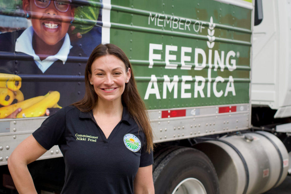 Commissioner Nikki Fried poses in front of a Feeding America truck while touring Pero Farms.