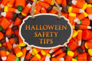 Halloween Safety Tips Message with candy corn on a hanging retro chalkboard