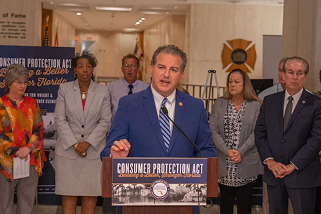 Jimmy Patronis stands at podium and speaks at press conference.