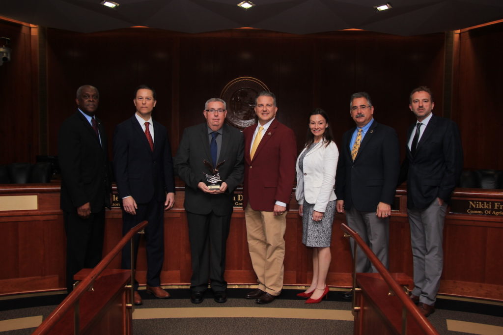 The Florida Cabinet pictured with Insurance Fraud Detective DeWayne White, the 2019 Law Enforcement Officer of the Year.