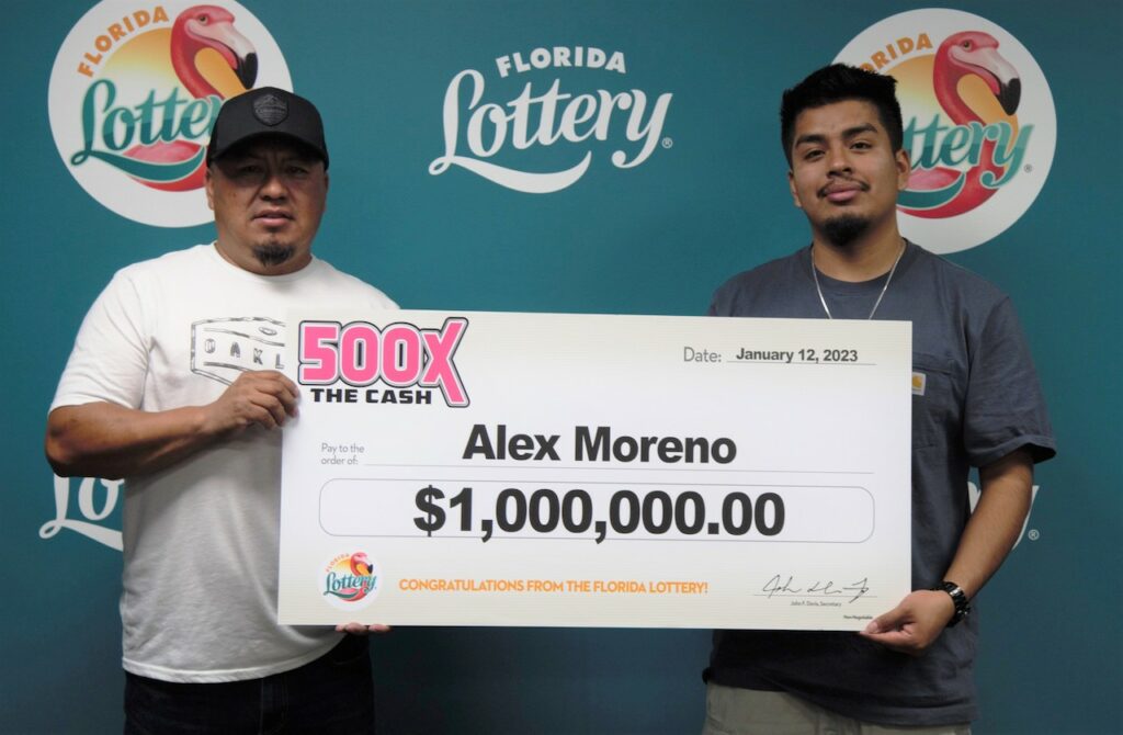 Alex Mendoza Moreno poses with family and oversized check after claiming a $1 million prize from the 500X THE CASH Scratch-Off game at Florida Lottery Headquarters in Tallahassee.