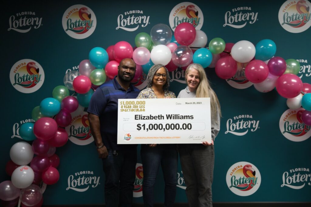 Elizabeth Williams (center) poses with two other members of the Lucky Lotto Champs group and oversized check after claiming a $1 million prize from the $1,000,000 A YEAR FOR LIFE SPECTACULAR Scratch-Off game at Florida Lottery Headquarters in Tallahassee.  