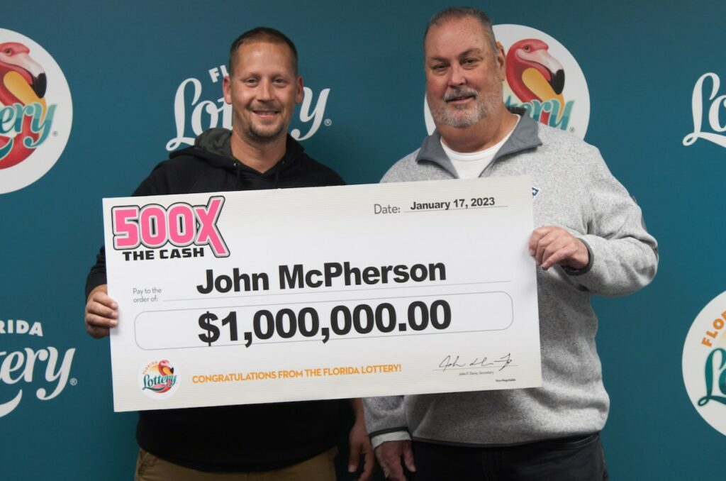 John McPherson poses with family and oversized check after claiming a $1 million prize from the 500X THE CASH Scratch-Off game at Florida Lottery Headquarters in Tallahassee.