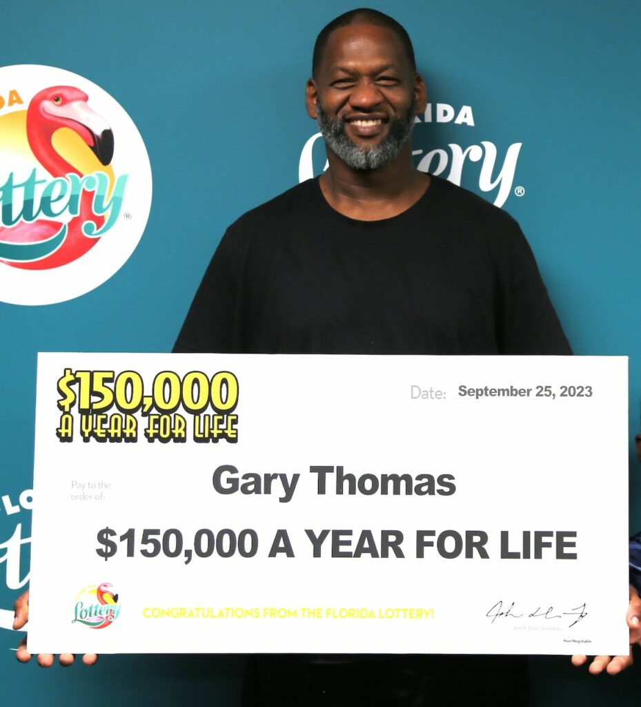 Beaming over his good fortune, Gary Thomas holds his oversized check showing he claimed a top prize from the $5 Scratch-Off game, $150,000 A YEAR FOR LIFE, at Florida Lottery Headquarters in Tallahassee.